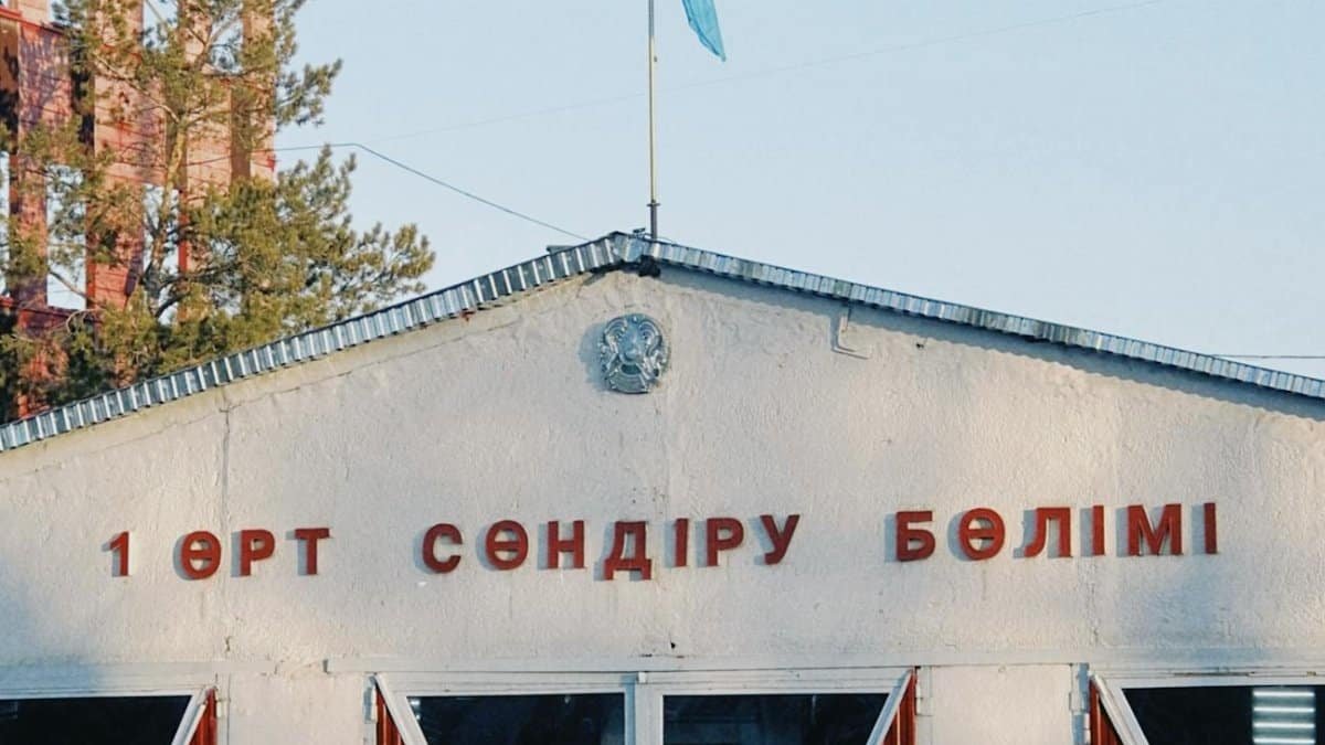 Fire station building in Konaev, featuring Kazakh flag and signage, captured in daylight.