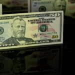 Crisp 50 dollar bill with reflection, offering a detailed view perfect for financial themes.