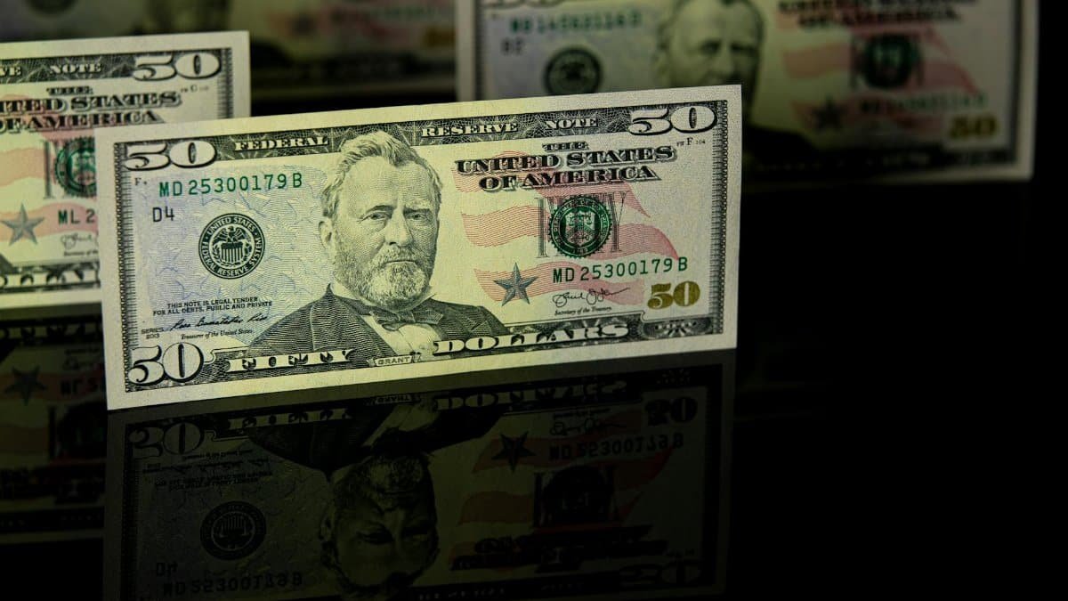Crisp 50 dollar bill with reflection, offering a detailed view perfect for financial themes.