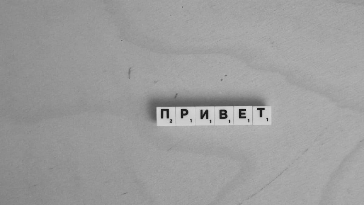Scrabble letters spelling 'Привет' on a wooden surface, highlighting language diversity.