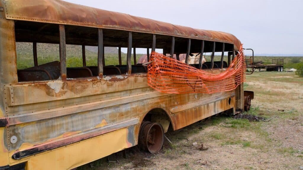 Explore a rusting, abandoned school bus in the Arizona desert, embodying decay and urban exploration.