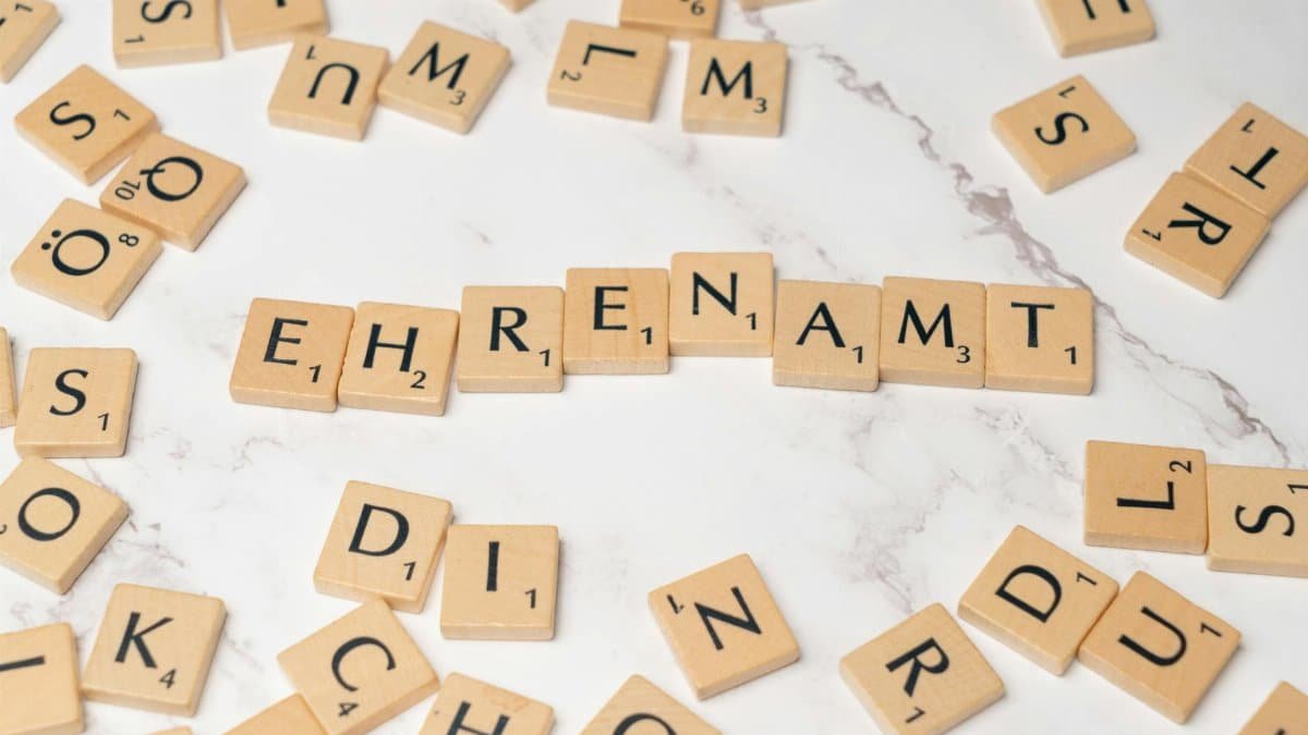 Close-up of Scrabble tiles spelling 'Ehrenamt', symbolizing volunteerism and community service.