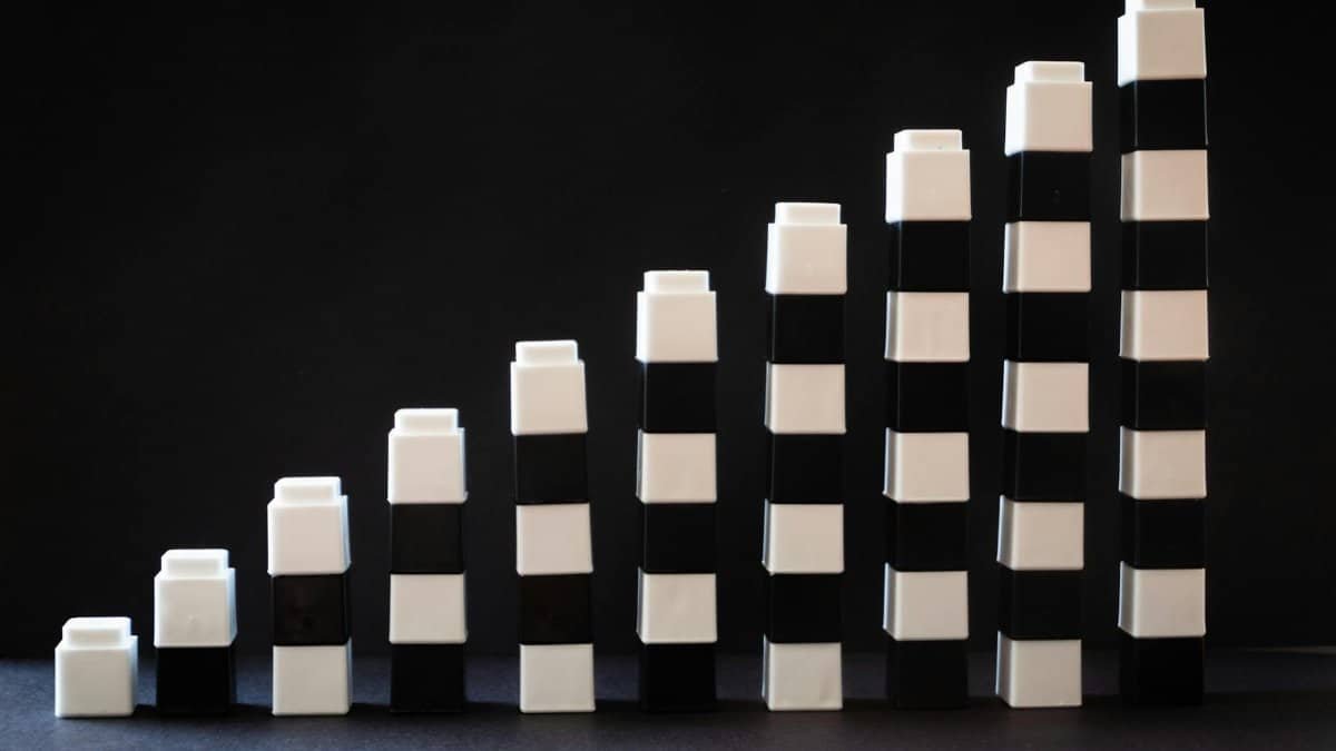 Black and white toy blocks arranged in ascending order to symbolize growth or progress.