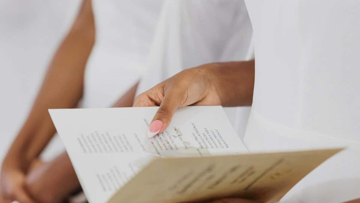 Close-up of a woman's hands holding a wedding ceremony program.