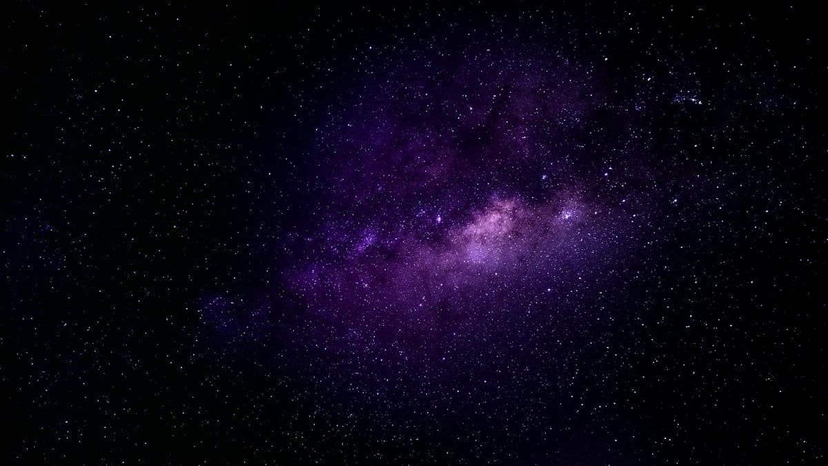 Immersive view of the Milky Way galaxy with vibrant purple hues under a clear night sky.
