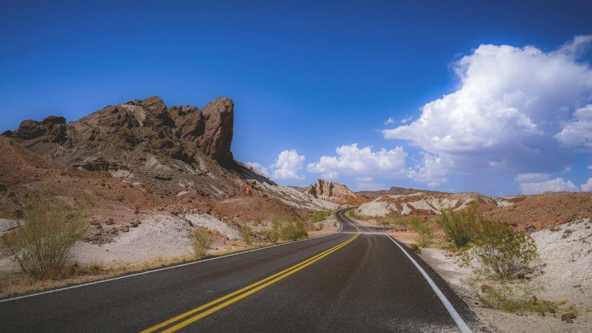 A winding road under a clear blue sky in Big Bend National Park, Texas.