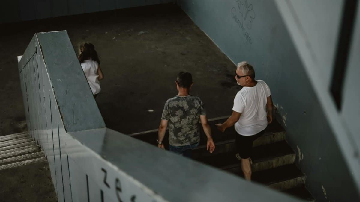 People descending a concrete urban staircase, captured from above in a moody tone.