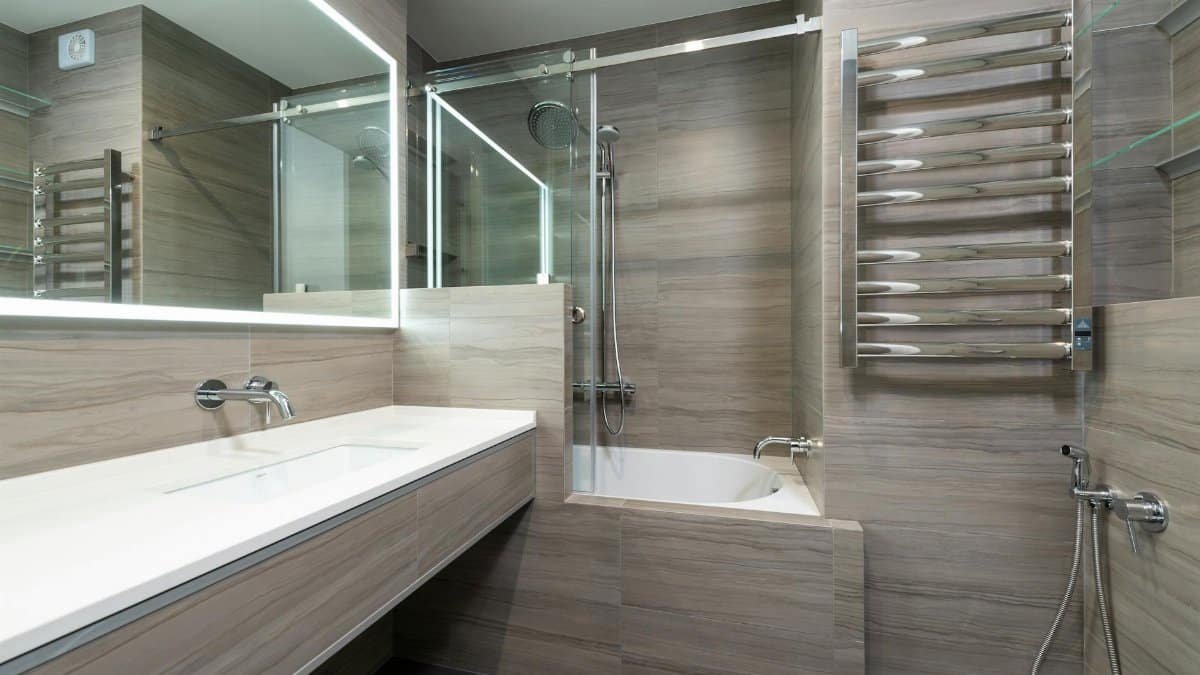 Elegant modern bathroom featuring a bathtub, shower, and sleek stainless steel fixtures.