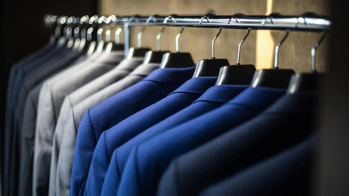 Close-up of neatly arranged suits in a wardrobe, showcasing fashion and organization.