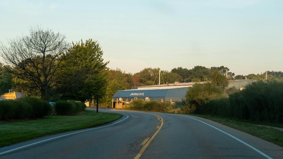 Serene evening view of a winding road leading to a building with natural surroundings in Holland, Michigan.