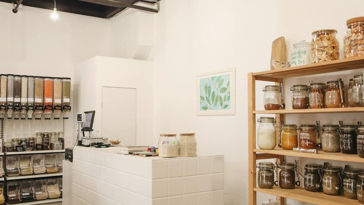Eco-friendly shop interior featuring wooden shelves and bulk food storage for zero waste shopping.