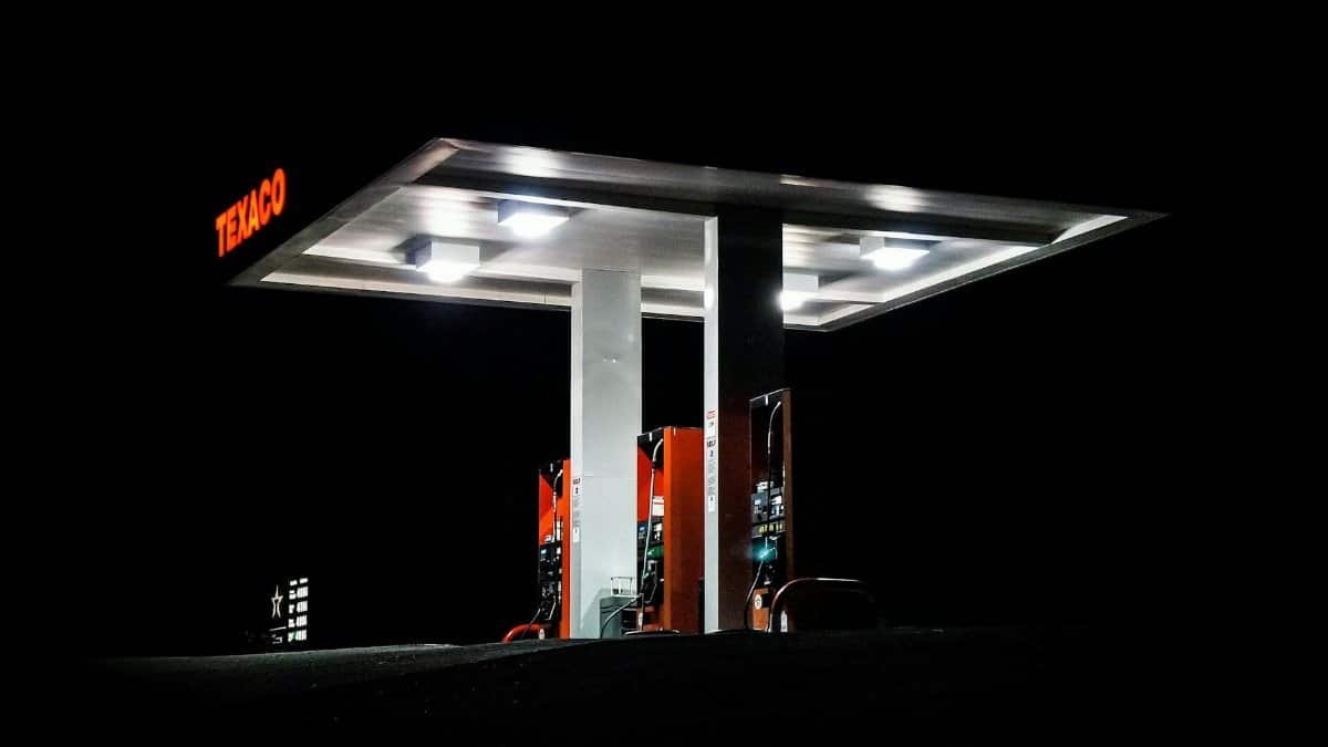 Night view of a Texaco gas station brightly illuminated with fuel pumps visible against a dark backdrop.