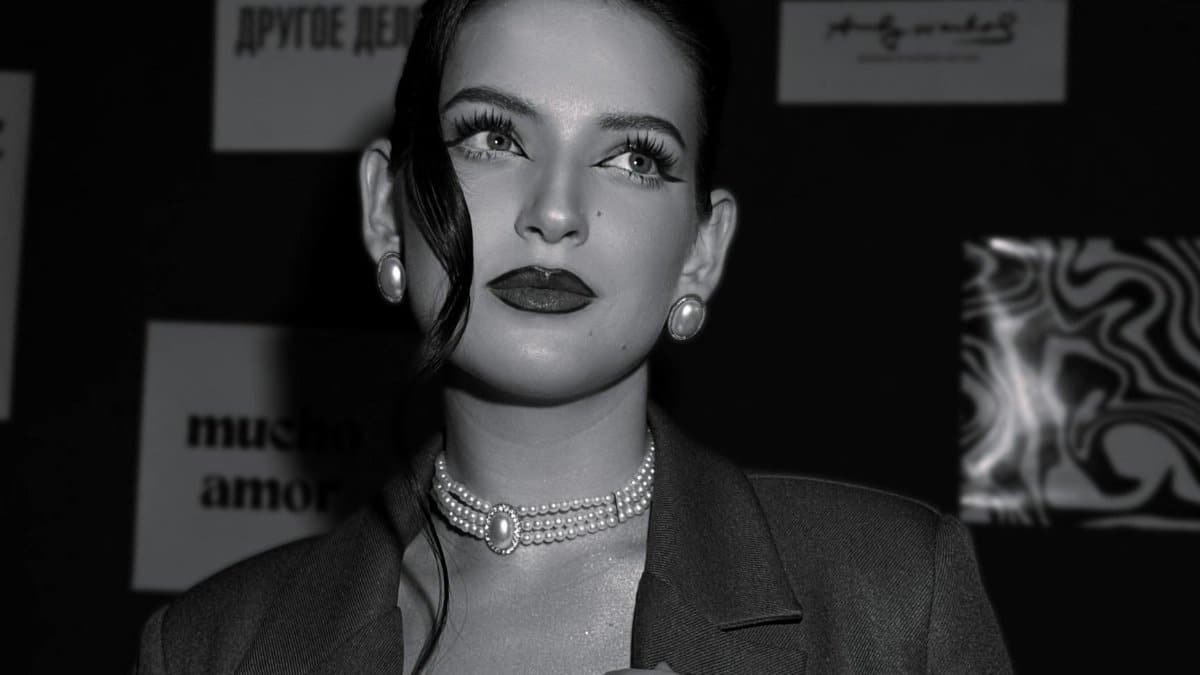 Stylish black and white portrait of an elegant woman wearing pearls and suit.