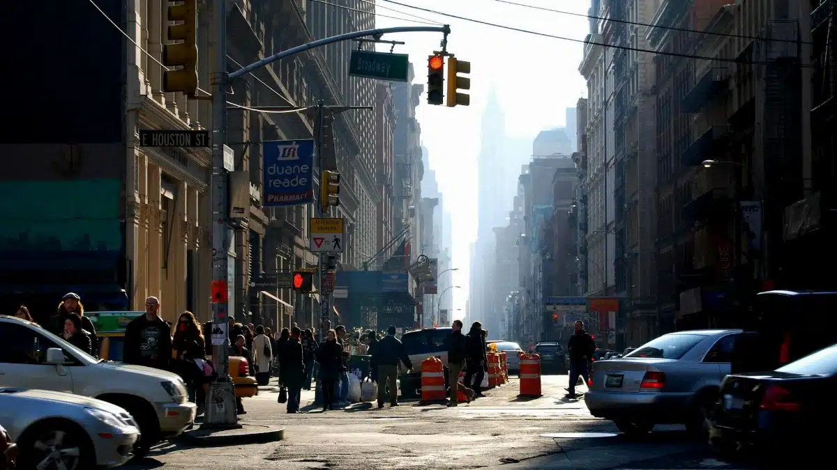 A bustling street scene in New York City with cars and people during daytime.