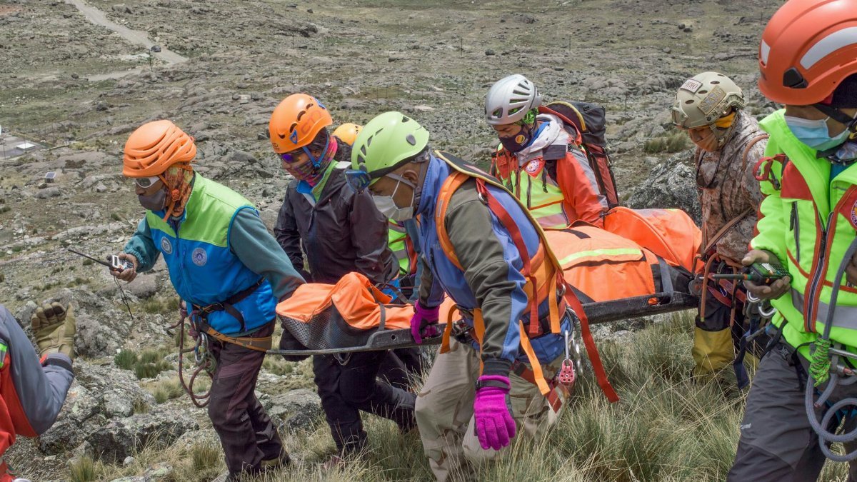 Rescue team carrying patient on stretcher during a mountain rescue in La Paz, Bolivia.