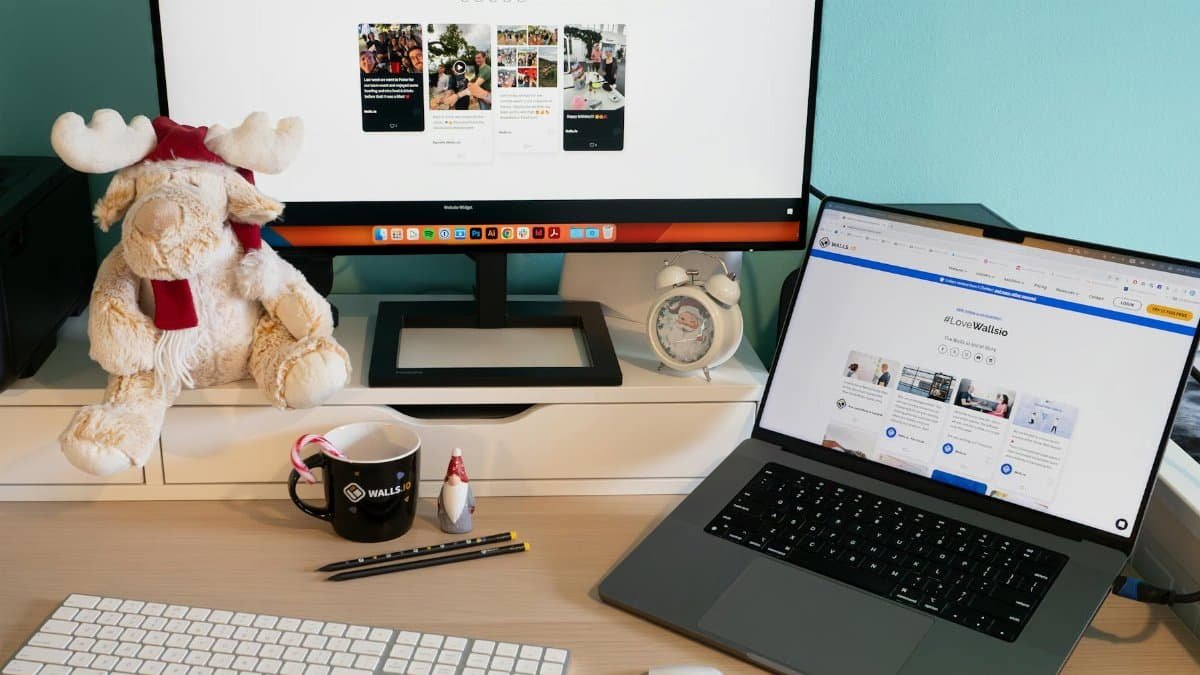 A well-organized home office desk featuring a monitor, laptop, and playful decor for a comfortable workspace.