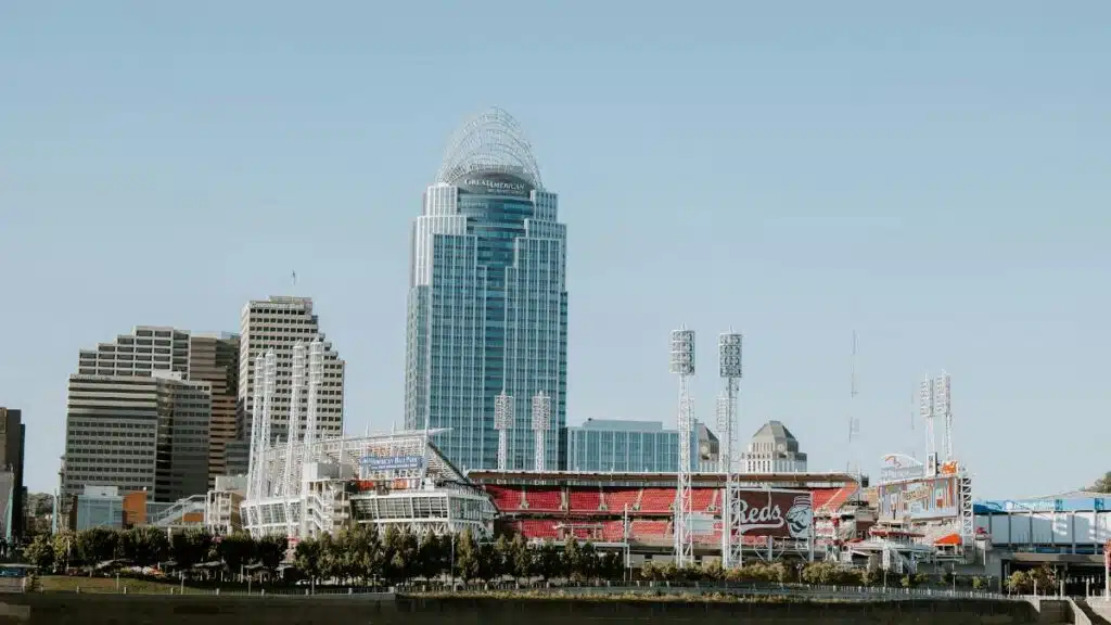 Photo of Cincinnati skyline with Great American Ball Park and modern skyscrapers, captured from a riverside view.