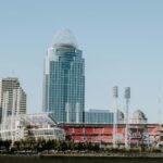 Photo of Cincinnati skyline with Great American Ball Park and modern skyscrapers, captured from a riverside view.