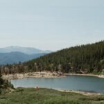 Tranquil mountain lake surrounded by evergreen trees in Idaho Springs, Colorado.