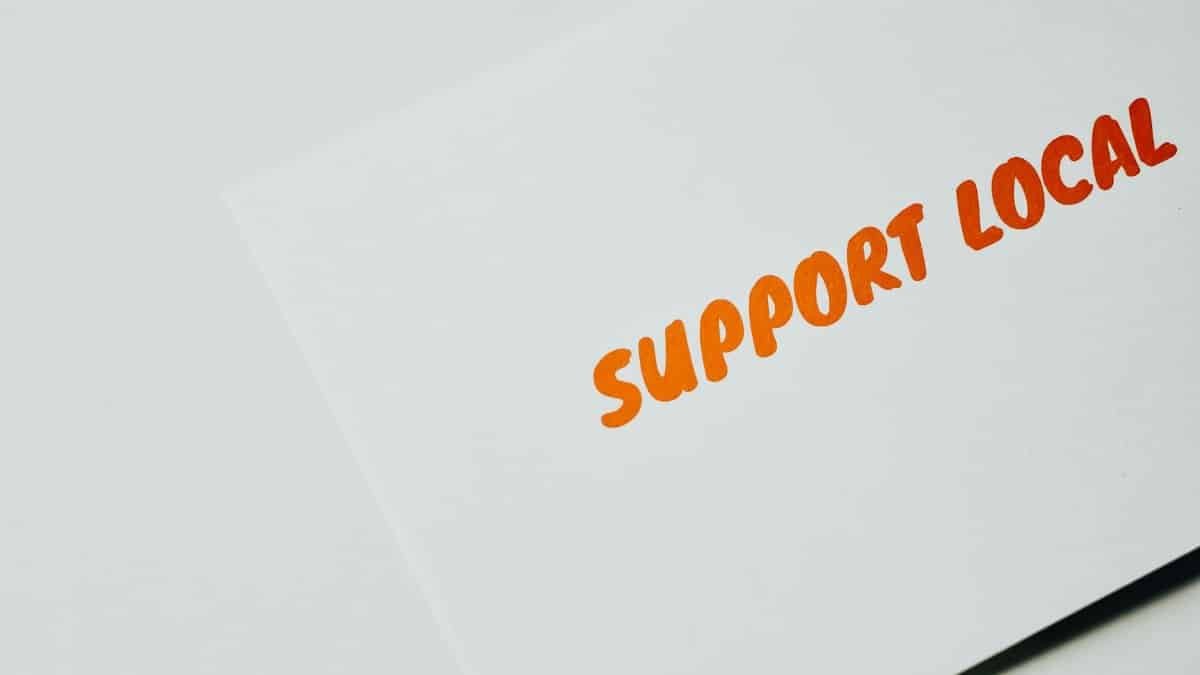 Close-up of 'Support Local' message on white paper, encouraging local support.