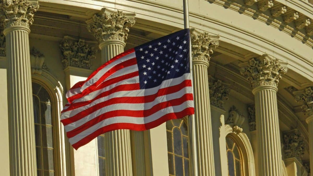 US flag waving outside the iconic US Capitol Building in Washington, DC.
