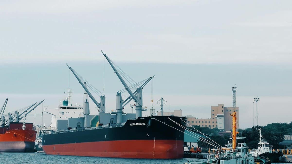 View of cargo ships docked at Davao harbor with tugboat assistance in Philippines.
