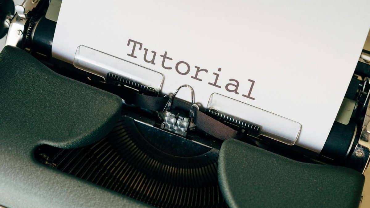 Close-up shot of a vintage typewriter with the word 'Tutorial' typed on paper.