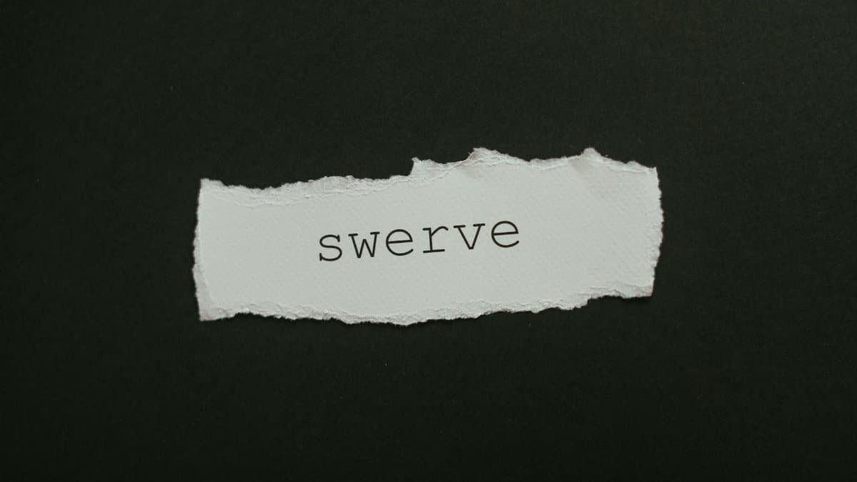 Close-up of torn paper with the word 'swerve' on a black background, ideal for concepts of change and direction.