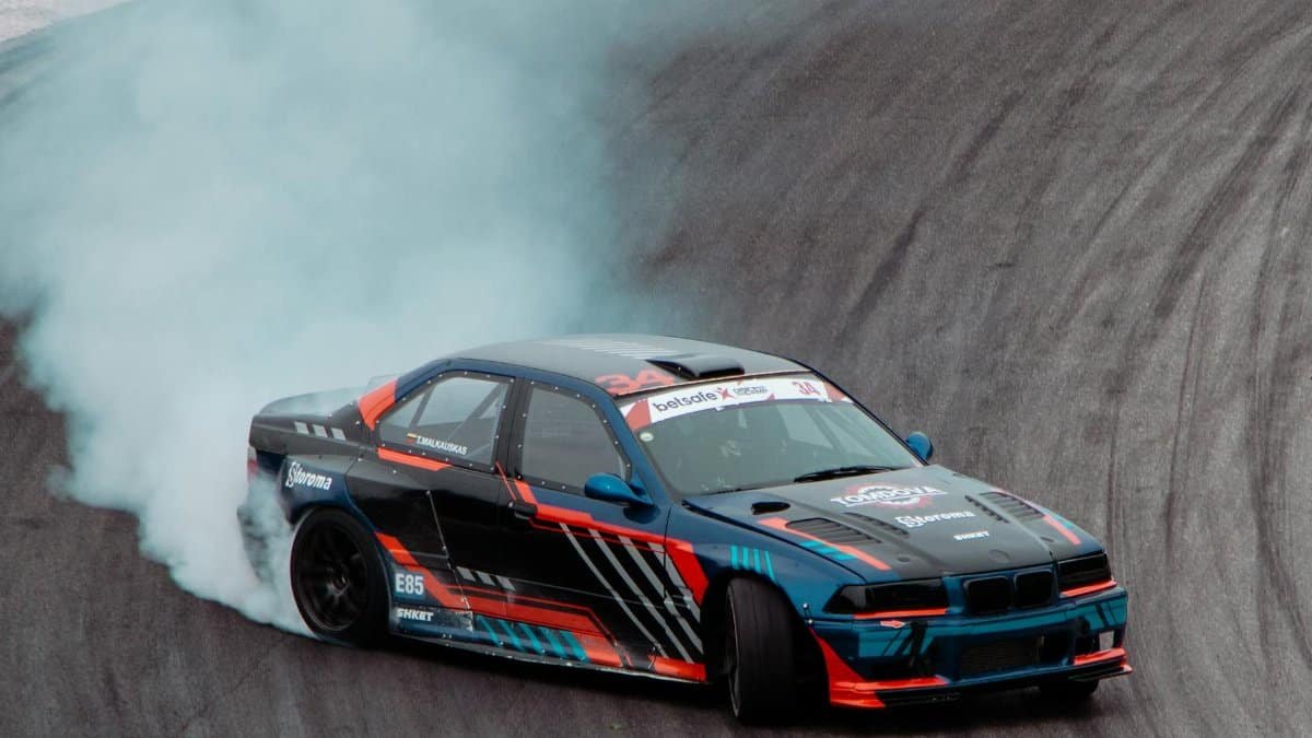 Dynamic drift race car in action on a racing track in Lithuania.