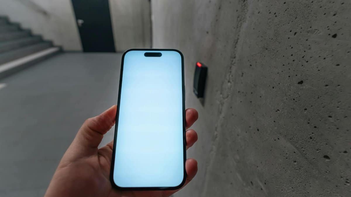 A smartphone unlocking a secure door using NFC technology in a modern building stairwell.