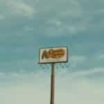 Cracker Barrel signpost with a clear blue sky background in Valdosta, GA, USA.