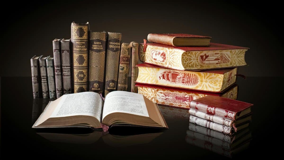 A collection of vintage books displayed elegantly on a reflective surface, ideal for education and literature themes.