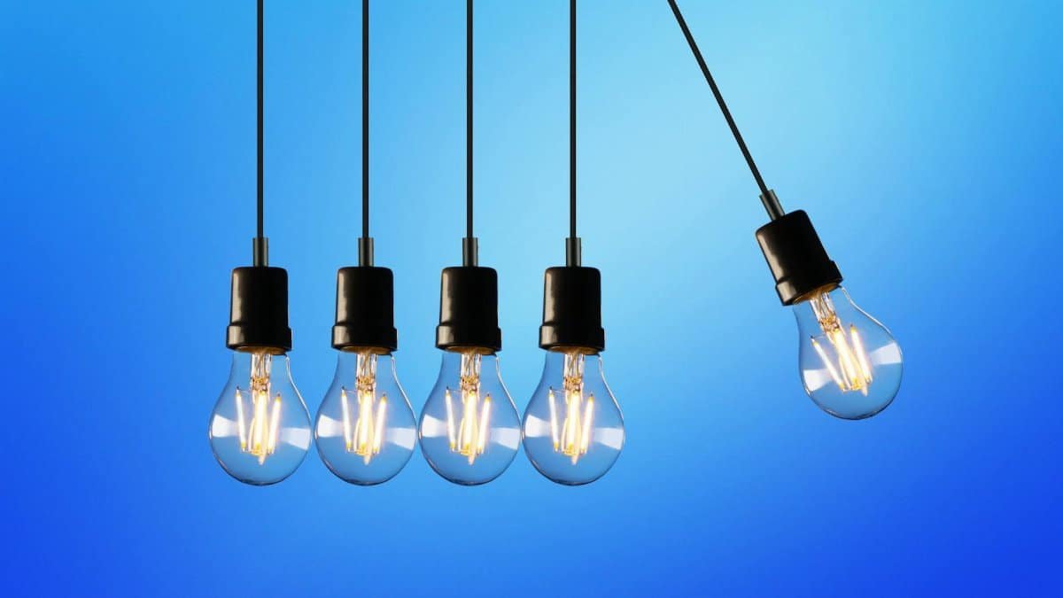 Hanging Edison-style light bulbs against a vibrant blue backdrop, showcasing energy and innovation.