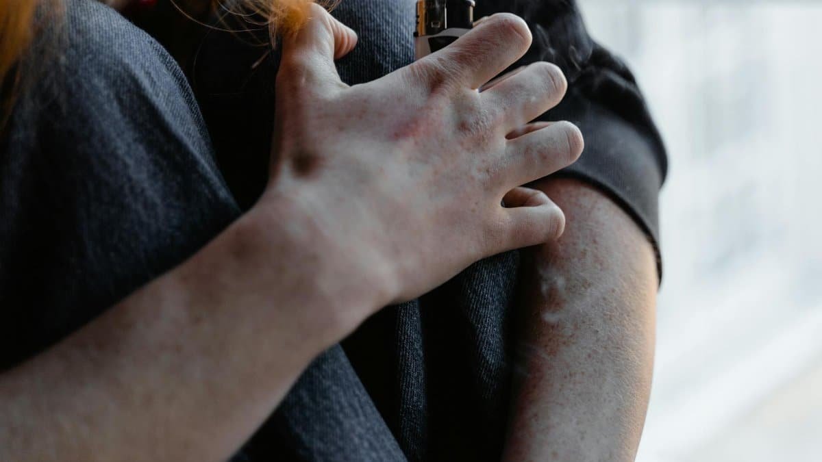 Dramatic close-up of a hand holding a lighter, conveying tension or anxiety.