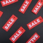 Top view of red sale tags on a black surface, perfect for marketing promotions.