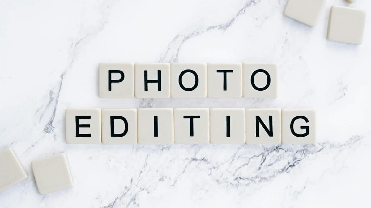 Close-up of 'photo editing' tiled letters on marble surface, perfect for digital design themes.