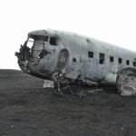 A crashed aircraft wreckage in a deserted landscape, evoking mystery and history.