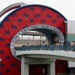 Capture of the Tokyo Disney Resort entrance featuring the Bon Voyage Store and pedestrian bridge.