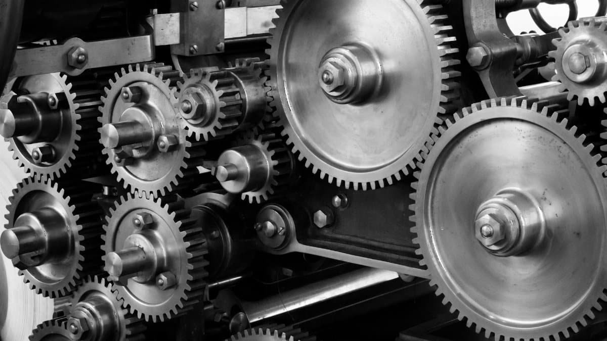 Close-up view of a complex industrial gear mechanism in black and white.
