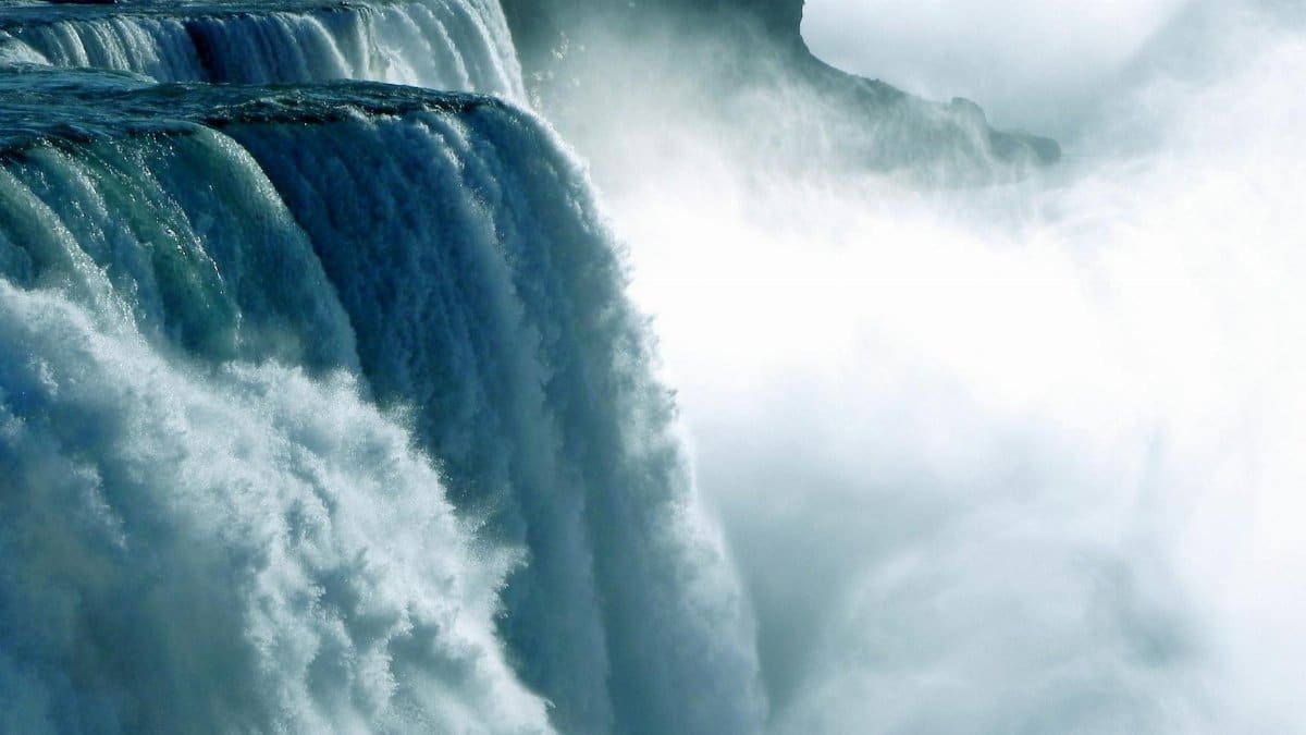Dramatic waterfall cascading amid mist, capturing the power of nature in daylight.