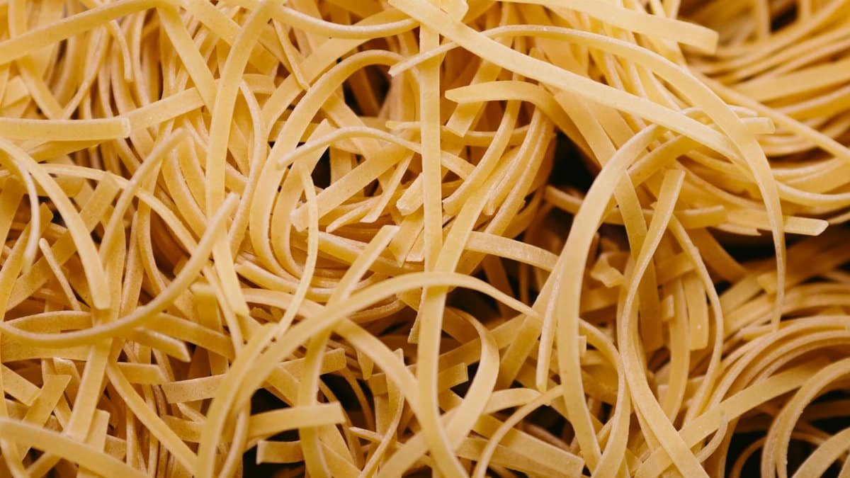 Detailed macro shot of uncooked pasta noodles, showcasing texture and intricate patterns.