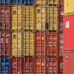 Colorful shipping containers stacked in a port for transport logistics.