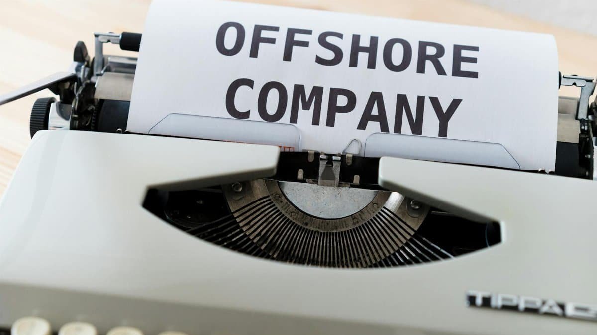 Close-up of a vintage typewriter writing 'Offshore Company' on a paper sheet.