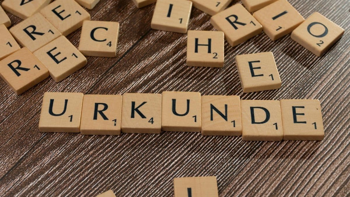 Wooden Scrabble tiles arranged on a textured surface forming words.