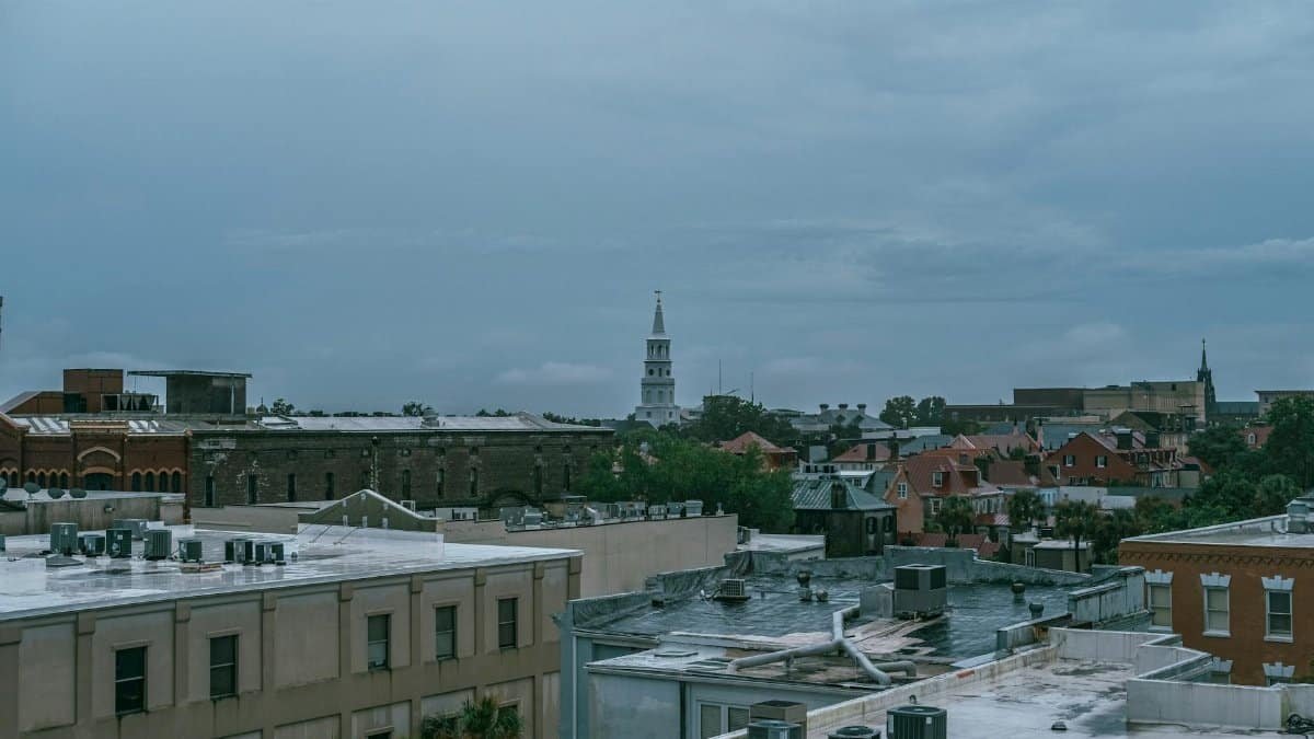 Aerial cityscape of Charleston, SC showcasing historic architecture under a cloudy sky.