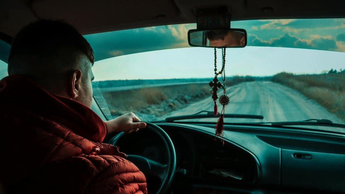 A man drives down a rural road at dusk, showcasing travel and exploration.
