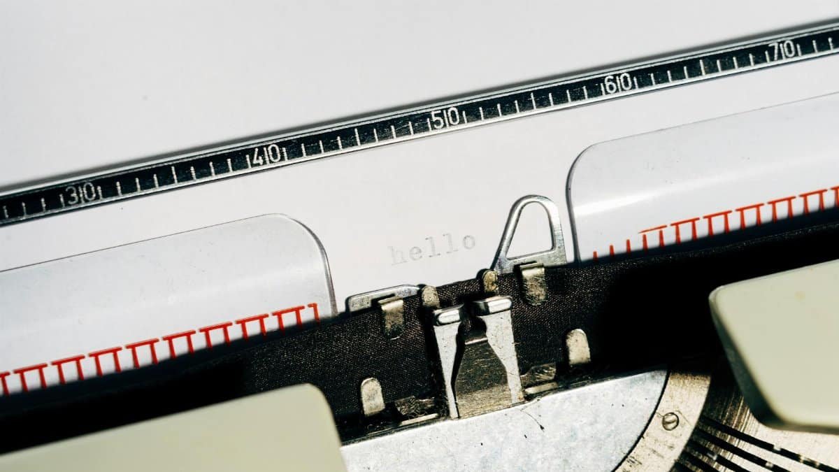 A vintage typewriter typing 'hello' on white paper, close-up view.
