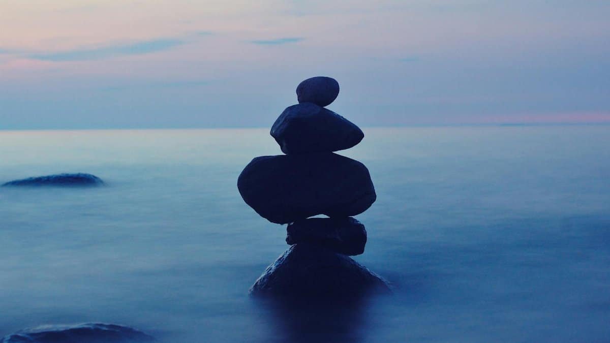 A calming seascape featuring stacked stones at twilight, symbolizing balance and tranquility.