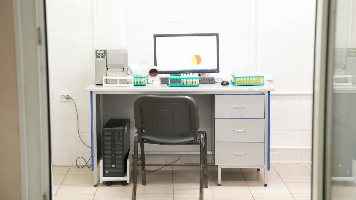 A clean and organized laboratory workstation with computer and lab equipment ready for research and analysis.