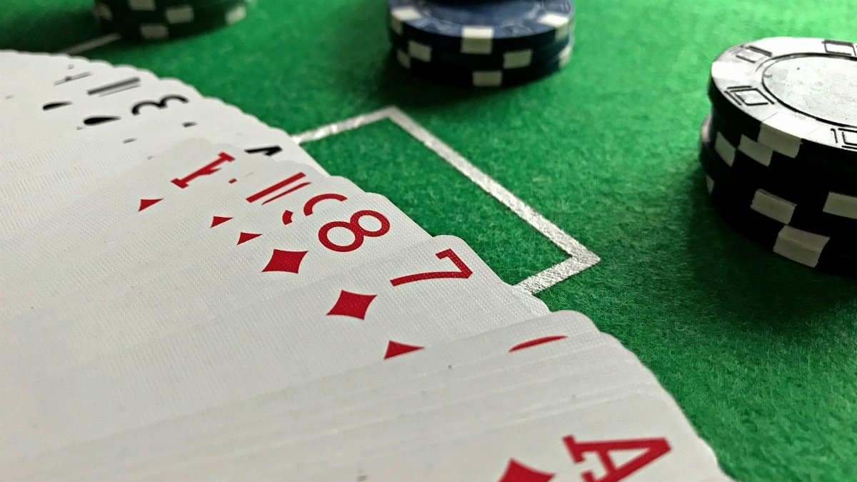 Close-up view of poker cards and chips on a green felt table, perfect for casino-themed content.